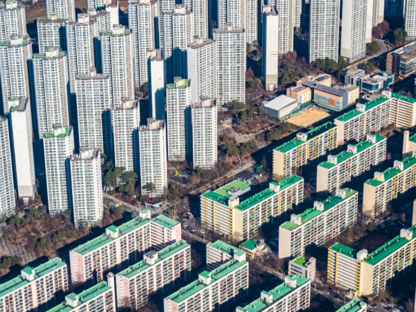 rial view of high-rise apartment buildings and older housing blocks, showing urban density and contrast in development styles, often linked to gentrification.