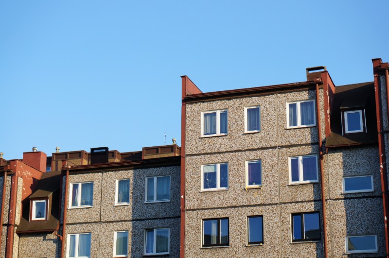 Multi-unit apartment building with residential windows, representing rental housing availability in urban areas.